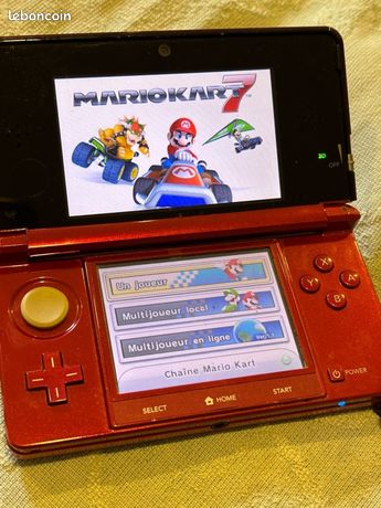 Console de jeux Nintendo 3ds rouge avec un jeu et chargeur